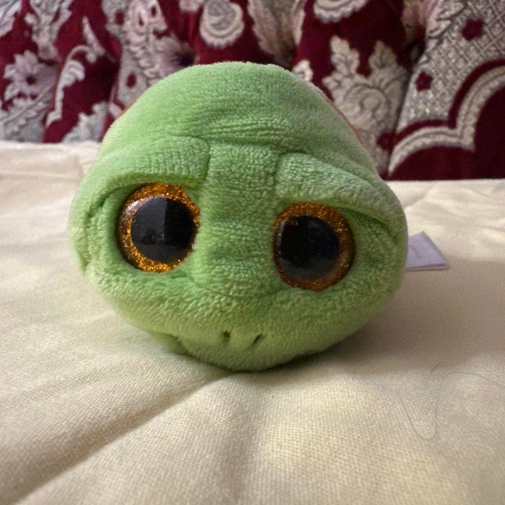 Green turtle plushie with glittery gold eyes